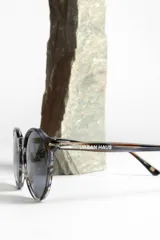 Lentes de sol unisex con montura redonda de carey y lentes polarizadas grises.