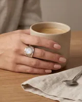 Anillo de plata 925 con diseño de estructura abierta y piedra de la luna central en forma oval.