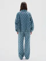 Campera bomber de denim con estampado de cuadros tipo argyle en tonos de azul. Presenta cierre metálico frontal, bolsillos delanteros con solapa y botón, y un ajuste oversized.