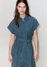 Vestido midi de corte recto color azul, con cuello camisero, mangas cortas y cierre delantero con botones ocultos. Incluye un cinturón ajustable del mismo tejido para anudar en la cintura.