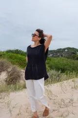 Chaleco negro de alpaca tejido a mano, ligeramente oversize, con hombros anchos, cuello tipo bote, puntos calados en frente y espalda, y tajos laterales en el bajo.