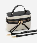 Cartera pequeña tipo bandolera de la marca Satinato, color beige con detalles en negro, confeccionada en una mezcla de algodón y poliuretano con forro de poliéster. Cuenta con tapa con doble cierre, cordón decorativo, asa de mano y correa larga removible.