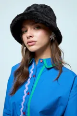 Sombrero tipo bucket de textura afelpada y suave, con diseño de abrigo en color negro.