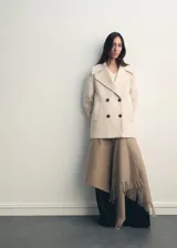 Abrigo corto de corte recto y diseño cruzado, confeccionado en tejido mezcla de lana. Presenta cuello con solapas de muesca, cierre frontal con botones oscuros y dos bolsillos laterales. Cuenta con forro interior y mangas largas.