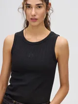 Musculosa básica de diseño crop con textura acanalada y cuello redondo. Presenta un pequeño logo bordado en el centro del pecho y terminaciones en rib.