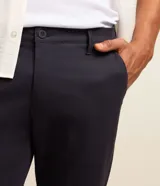 Pantalón de sastrería corte slim cropped, color negro, con cierre de botón y cremallera, trabillas para cinturón y bolsillos laterales y traseros.