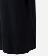Suéter de punto de corte oversize y largo alargado, con cuello alto, mangas largas y aberturas laterales sutiles. Presenta puños y ruedo con acabado acanalado.