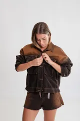 Campera de denim azul con calce boxy, cuello clásico, cierre con botones metálicos, mangas largas con puños abotonados, dos bolsillos frontales con solapa y parche con logo en el frente.