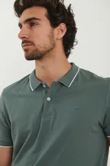 Chomba azul marino de piqué con cuello clásico y tapeta de dos botones. Detalles de ribete blanco en cuello y mangas.