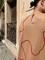 Vestido midi sin mangas color beige con estampado de líneas onduladas color ladrillo.