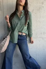 Camisa de manga larga color verde militar, con cuello camisero, cierre frontal de botones y detalles de bordados y calados en el frente y las mangas.