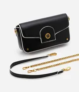 Bolso negro tipo baguette con correa de cadena dorada y correa corta blanca. Tiene cierre de tapa con broche dorado con el logo STN.