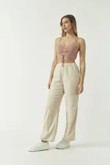 Top de punto color menta con escote en V, tirantes finos y detalle de fruncido central ajustable con cordón. Presenta un diseño corto y entallado.