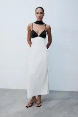Vestido largo lencero con diseño bicolor en blanco y negro, escote en pico, tirantes finos ajustables, espalda descubierta y foulard incorporado a contraste.