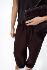 Pantalón de corte holgado en tejido liviano de mezcla de lino. Modelo de tiro alto con cintura elástica y cordón para ajustar, bolsillos laterales y piernas rectas.