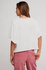 Remera de jersey de algodón blanca con silueta murciélago, escote barco y mangas dolman muy anchas de corte recto y holgado.