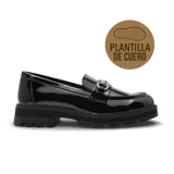 Zapato tipo mocasín de mujer en charol negro, con suela track dentada y detalle de herraje metálico en el empeine.