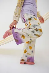 Pantalón de pierna ancha con estampado de hojas y flores, cintura elastizada y bolsillos laterales.