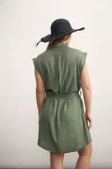 Vestido camisero corto negro con cuello clásico, solapas, cierre frontal con botones, cinturón de lazo y bolsillos laterales.