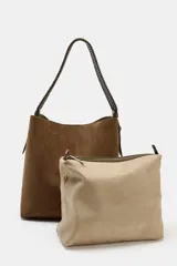 Bolso de hombro formato saca en color marrón, con asa superior trenzada y cierre mediante clip metálico. Incluye compartimento interior extraíble con cremallera.