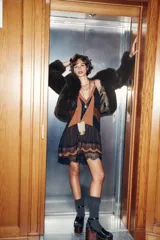 Vestido corto con tirantes finos ajustables, escote en V profundo con paneles en color negro y marrón. Presenta detalles de encaje marrón en el torso y un bajo con volantes de tul negro y encaje festoneado.