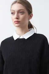 Sweater negro de tejido tramado con relieve, de calce cómodo y cuello redondo.