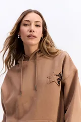 Canguro con capucha y cordones ajustables, de silueta amplia y caída relajada. Presenta un bolsillo frontal tipo canguro, puños y ruedo acanalados, y una estampa protagonista en la espalda.