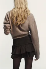 Falda pantalón de tiro medio con diseño de volantes en el ruedo y cierre lateral oculto.