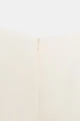 Mono corto rosa chicle, sin mangas, con cuello redondo y detalle de cruce o abertura frontal en la parte inferior. Presenta cierre oculto en la espalda.