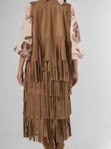 Falda larga de gamuza color marrón, con múltiples capas de flecos largos que le dan mucho movimiento.