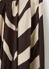 Pantalón largo de tiro medio confeccionado en viscosa fluida, con diseño recto y estampado de cebra en tonos marrón y beige. Cuenta con dos bolsillos laterales y cierre de botón.