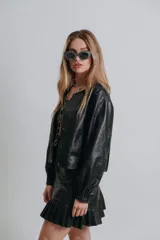 Campera bomber de cuero color marrón, con mangas abullonadas, puños elásticos y cierre frontal con botones a presión.