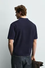 Polo de punto azul marino, de corte regular fit, con cuello solapa, abertura frontal en V y mangas cortas.