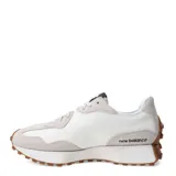 Championes urbanos New Balance modelo 327, con diseño retro inspirado en los años 70. Presentan una combinación de paneles de gamuza en tono gris claro y base de nylon blanco, con el logo 'N' en cuero sintético negro en el lateral. Incluyen una entresuela de espuma blanca y una suela de goma dentada que se extiende hacia el talón.