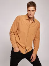 Camisa de manga larga confeccionada en tejido de franela de algodón con un toque de spandex. Presenta cuello clásico, cierre frontal con botones y un bolsillo en el pecho.