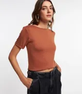 Blusa básica de cuello redondo y manga corta con detalle de dobladillo plegado. Confeccionada en tejido de viscosa con spandex, ofrece un ajuste cómodo y versátil.