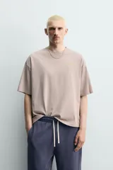 Camiseta boxy fit color gris topo, de cuello redondo y manga corta, con pequeño estampado frontal a contraste.