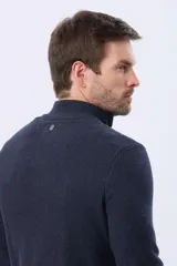 Buzo tejido texturado color beige, con cuello alto y cierre frontal parcial con detalle de cuero.