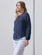 Blusa azul marino de Zac & Rachel con cuello a la base, abertura central con botones y detalle de broderie en el frente. Tiene mangas largas con terminación elastizada.