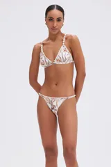 Top de bikini confeccionado en lycra con estampado tropical y retro, tirantes ajustables con cuentas decorativas y detalles de crochet en el busto.