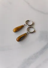 Aros colgantes de acero quirúrgico plateado con dije de piedra natural rosa en forma de lágrima.