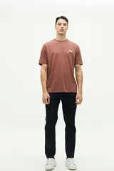 Remera marrón de manga corta con cuello redondo y estampado frontal con texto y flores.