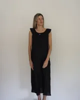 Vestido midi de lino color negro, de corte suelto, sin mangas y con escote redondo adornado con volados.