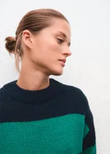 Jersey de punto de corte recto con diseño de rayas horizontales en verde y azul marino. Presenta cuello redondo y manga larga.