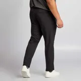 Pantalón de vestir de corte slim en color negro, con cierre frontal y bolsillos laterales. Presenta una línea de planchado marcada a lo largo de la pierna.