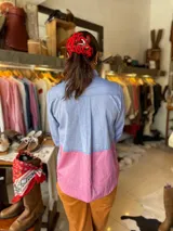 Camisa de algodón liviano con diseño patchwork en tonos celeste y rosado, de manga larga, cuello camisero y bolsillo frontal con parche.