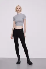 Pantalon skinny de tiro medio, confeccionado en tejido de algodón con elastano, con cierre frontal y bolsillos laterales.