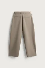 Pantalón relaxed fit marrón oscuro, de corte ancho y recto, con pliegues frontales, bolsillos laterales y cierre con botón y cremallera.