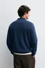 Polo de punto de corte regular fit, confeccionado en una mezcla de lana y cashmere. Presenta cuello solapa con cierre frontal de dos botones, manga larga y terminaciones en rib.