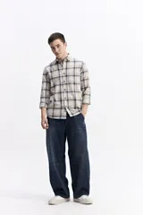 Camisa de manga larga confeccionada en viyela de algodón con diseño de cuadros en tonos azul y verde. Presenta cierre frontal con botones, cuello clásico y bolsillo en el pecho.